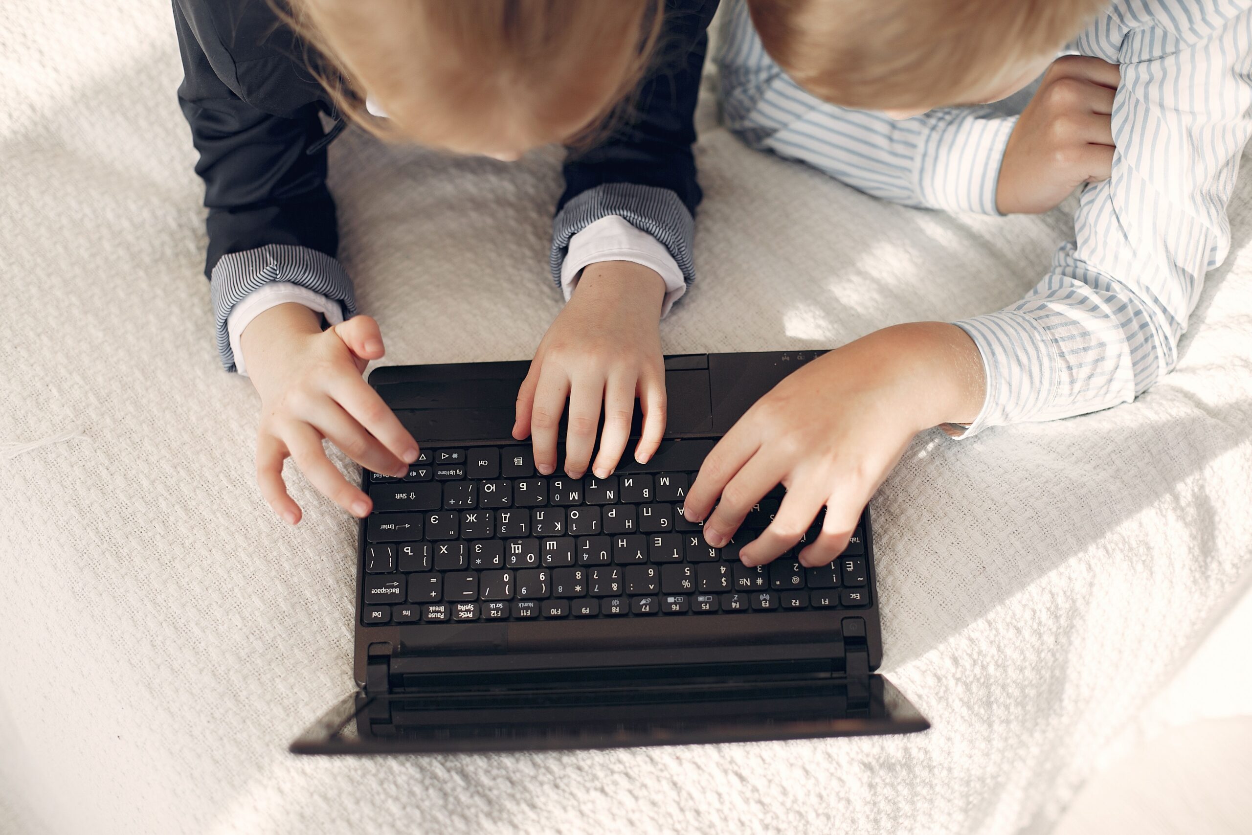 kinderen die typen op laptop